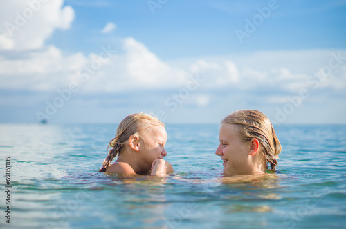 Young mother and daughter have fun swim on island in tropical oc © Joshhh