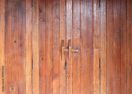 Door handle on brown wood door © sutichak