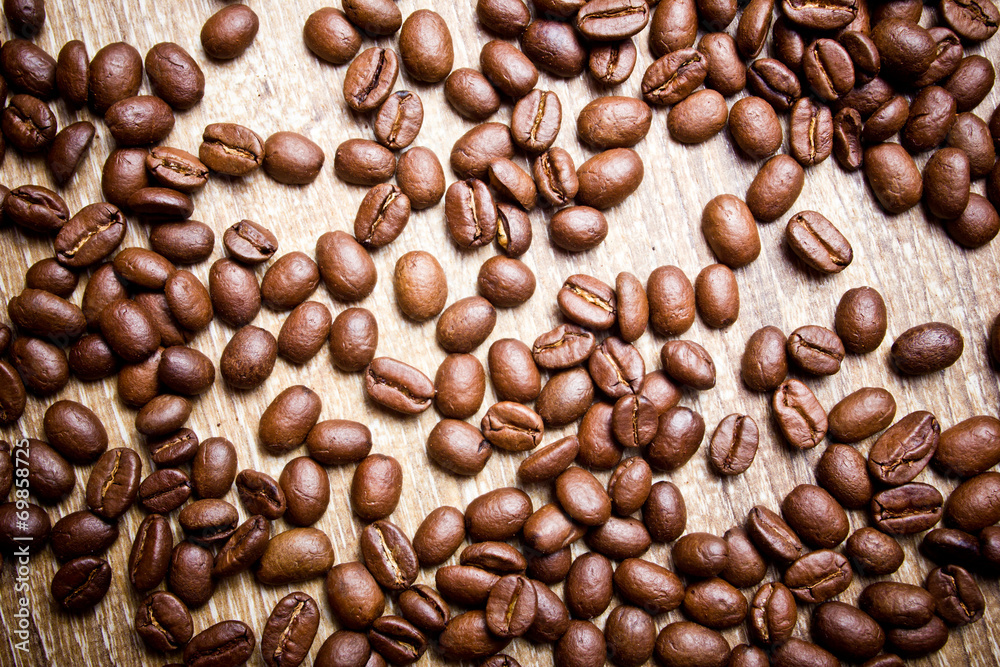 Fototapeta premium Coffee seeds on wooden surface texture. 