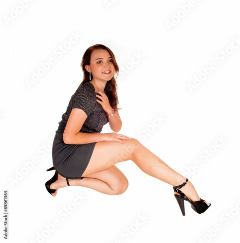 Teen girl kneeling on floor.