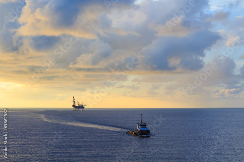 Offshore jack up drilling rig and supply boat © bomboman