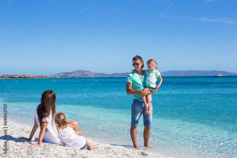 Happy family of four have fun on tropical beach Happy family of four have fun on tropical beach
