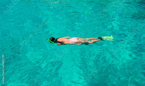 Beautiful girl snorkeling in clear tropical turquoise waters