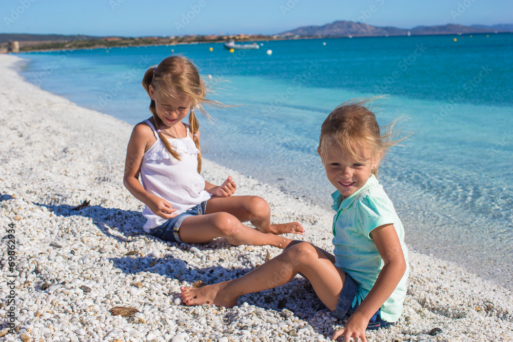 Adorable cute girls have fun on white beach during vacation Adorable cute girls have fun on white beach during vacation