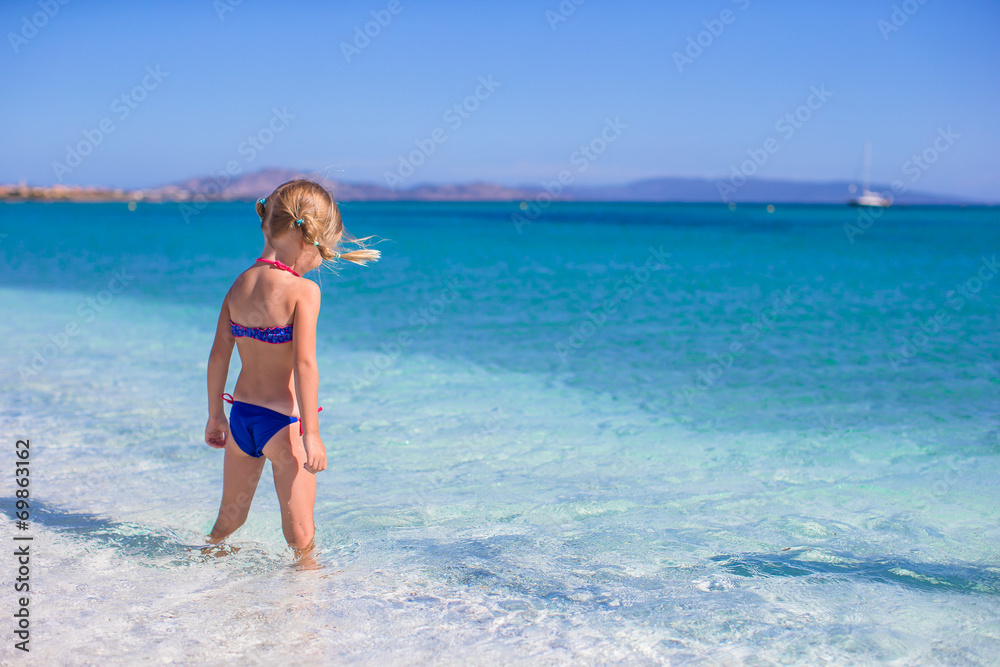 Adorable little girl in shallow water have fun at white beach Adorable little girl in shallow water have fun at white beach