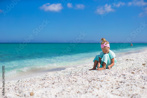 Adorable little girl on white tropical beach