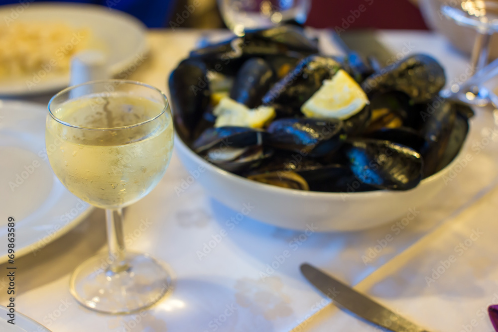 Mussel with white wine sauce at plate on table