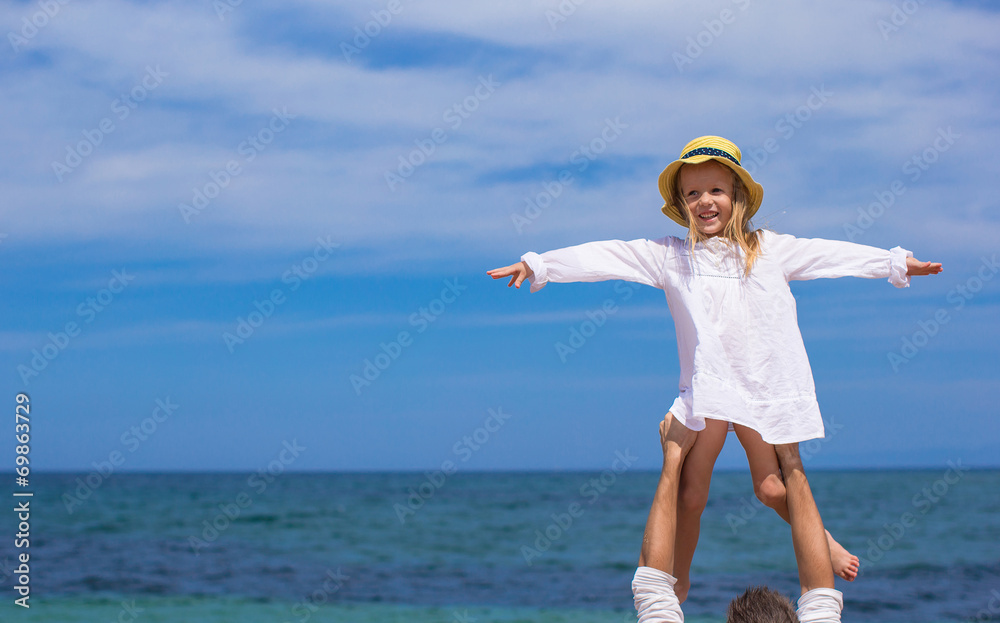 Young father and cute little daughter have fun during beach