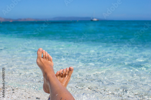 Closeup of female legs background of the turquoise sea