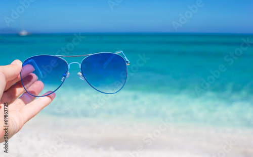 Close up of colorful blue sunglasses on tropical beach