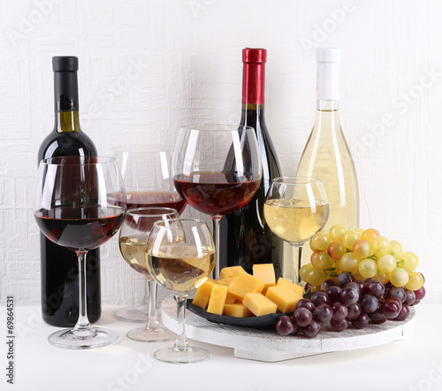 Bottles and glasses of wine  cheese and ripe grapes