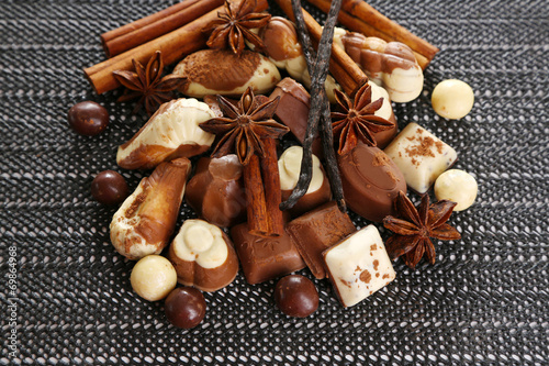 Different kinds of chocolates with spices on dark background