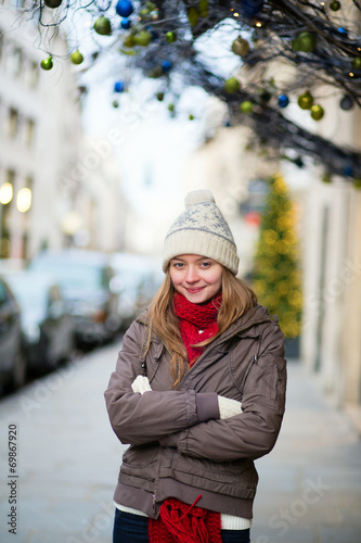 Girl on a Parisian street decorated for Christmas