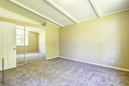 Empty old house interior. Bright yellow room with mirror door cl