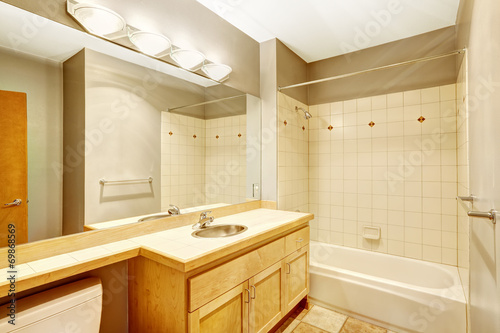 Empty bathroom with tile wall trim and light tone cabinet