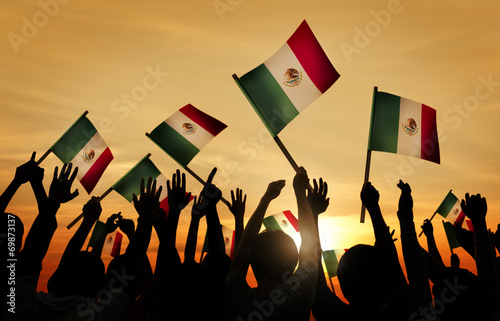 Fotografi Silhouettes of People Holding Flag of Mexico