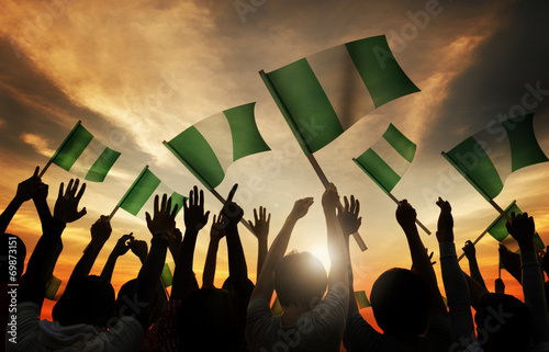 Silhouettes of People Holding Flag of Nigeria photo