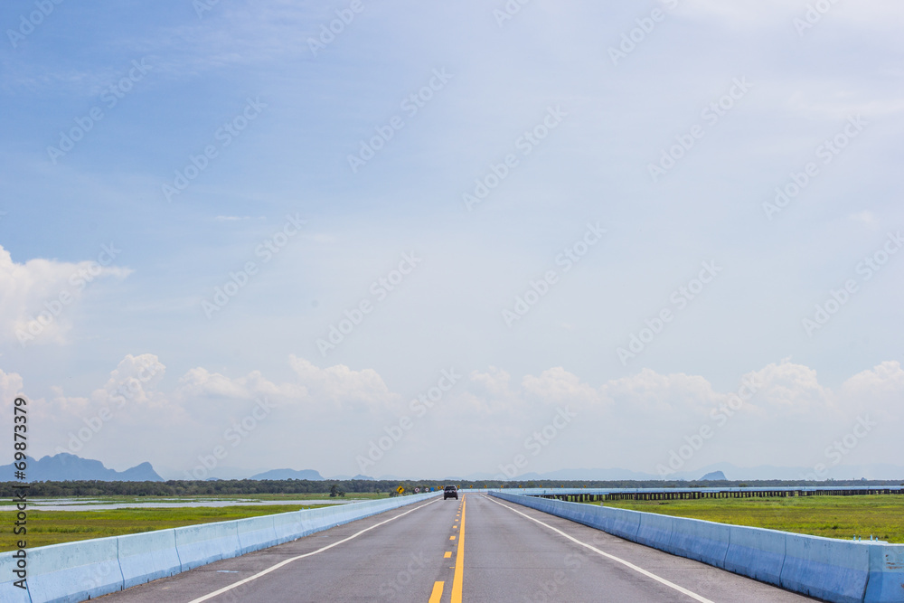 Running cars on the road with blue sky