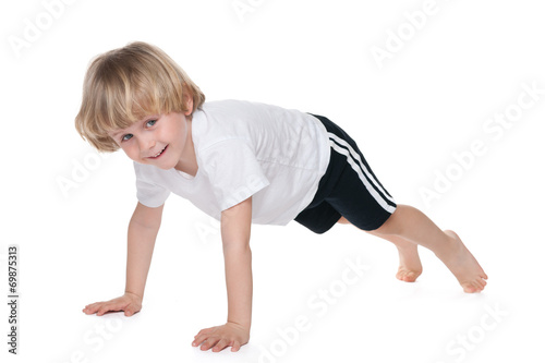 Cute boy performs gymnastic exercises