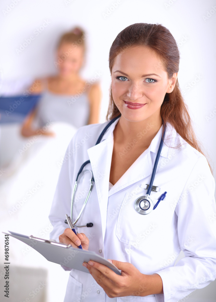 Smiling female doctor with a folder in uniform standing at Smiling female doctor with a folder in uniform standing at