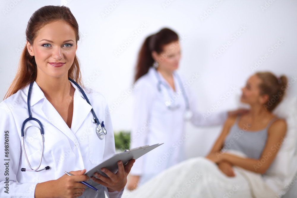 Smiling female doctor with a folder in uniform standing at Smiling female doctor with a folder in uniform standing at