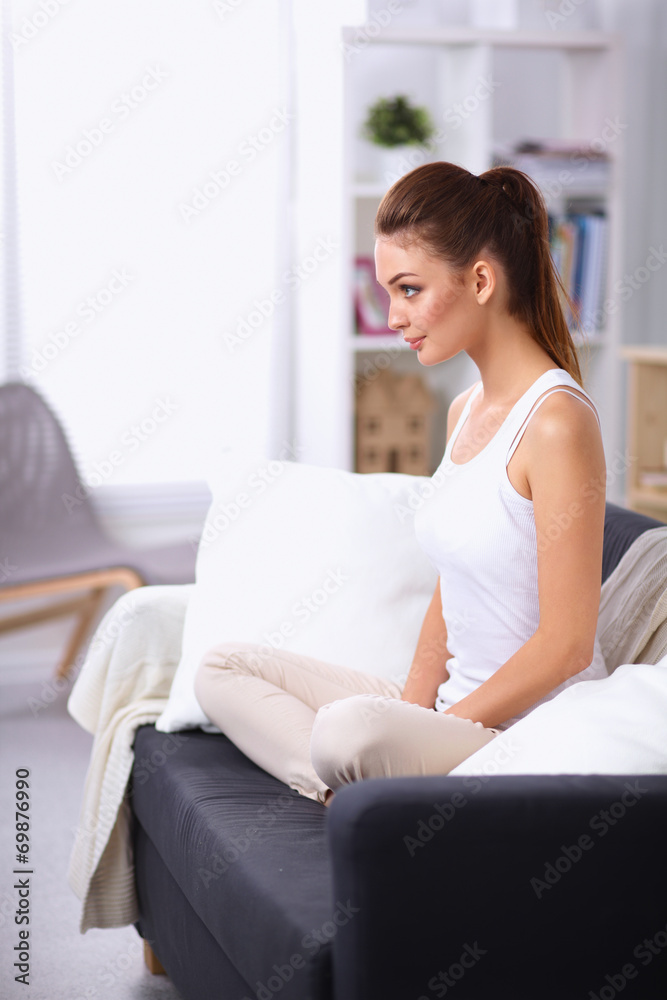 Woman sitting on the couch in  living room and smiling