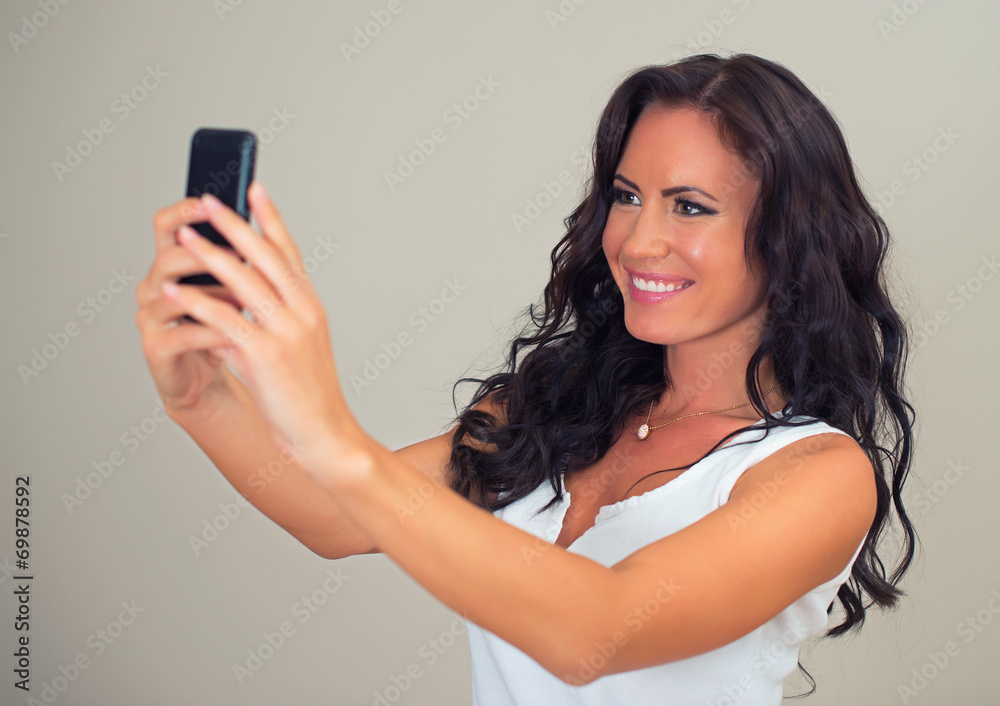 Attractive brunette taking selfie with cellphone. Attractive brunette taking selfie with cellphone.