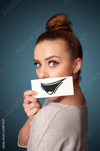 Happy cute girl holding paper with funny smiley drawing