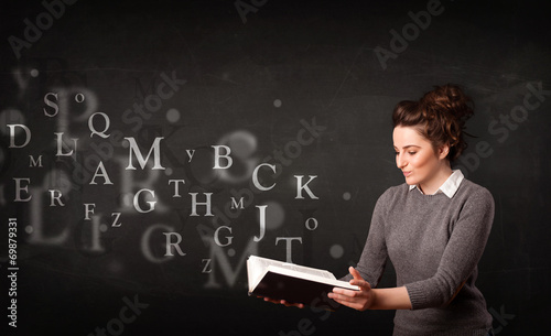 Young lady reading a book with alphabet letters
