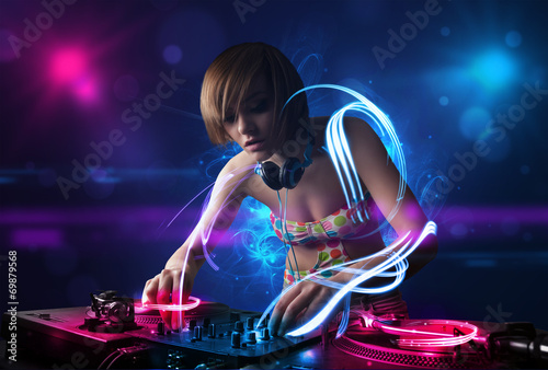 Disc jockey playing music with electro light effects and lights photo