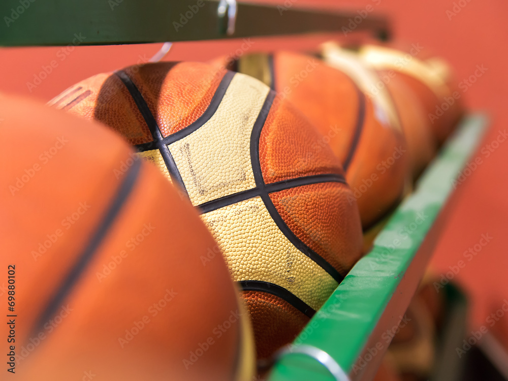 Naklejka premium row of basket balls in gymnasium