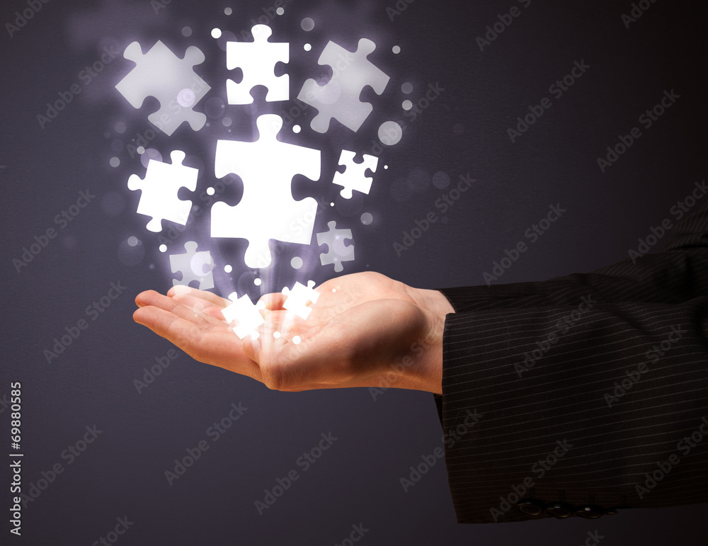 Puzzle pieces in the hand of a businessman Puzzle pieces in the hand of a businessman