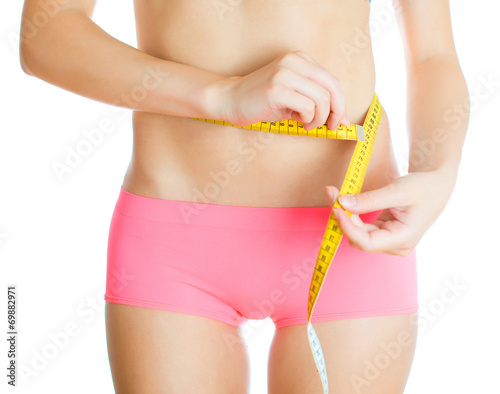 Weight loss concept. Woman measuring herself. Isolated on white.