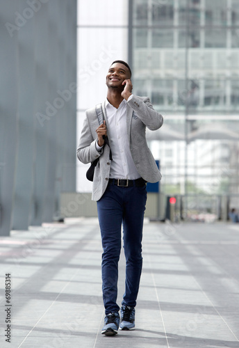 Cool guy walking and talking with cellphone