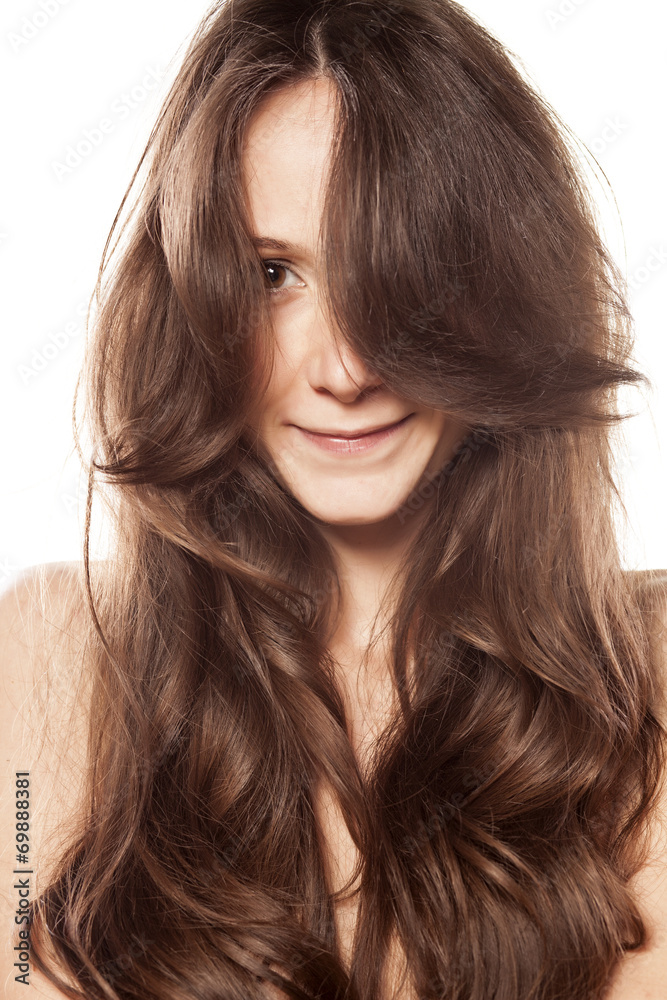 smiling young woman with no makeup with hair over half a face