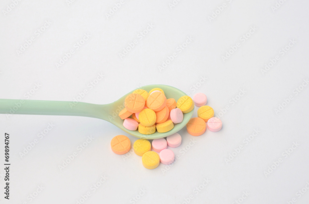 colorful medicine tablet on the spoon colorful medicine tablet on the spoon
