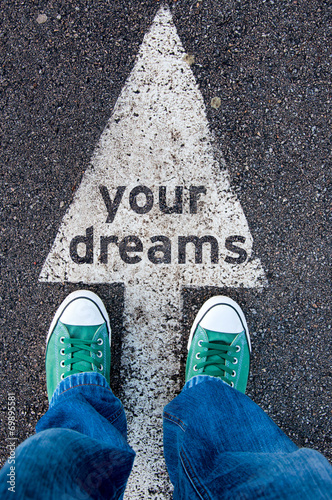 Green shoes standing on your dreams sign