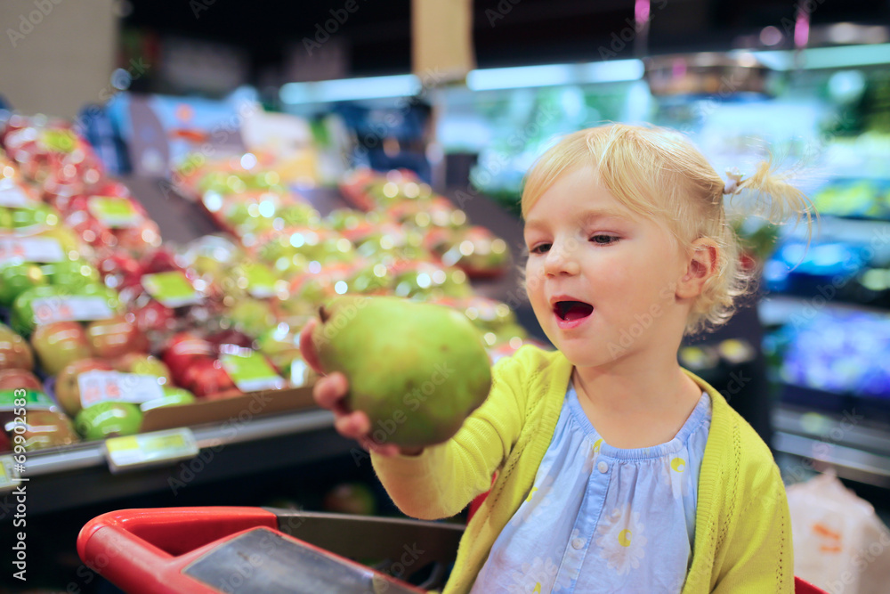 Fototapeta premium Little girl doing shopping in supermarket