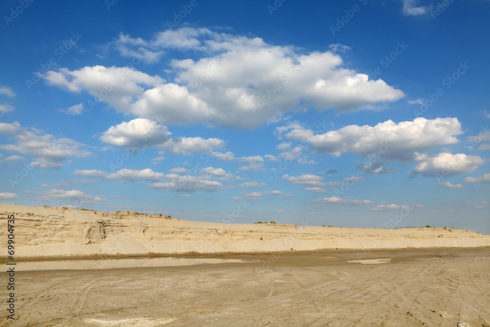 Sand quarry, heap of sand and puddle, beautiful landscape