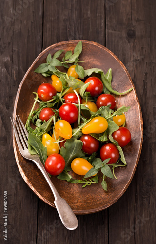 Red and yellow tomatoes with herbs and fork