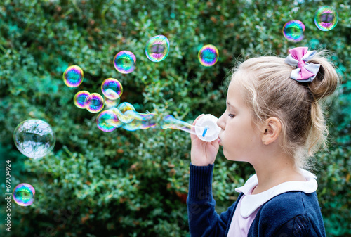 cute little girl blowing soap bubbles