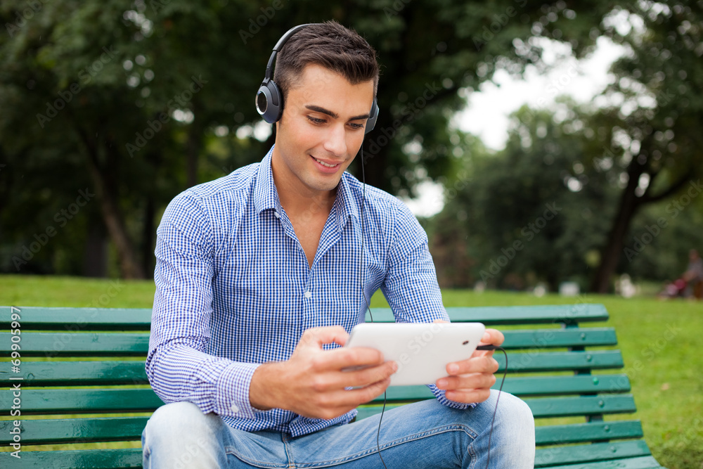 Fototapeta premium Man listening music in a city park