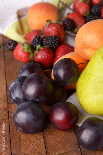 Ripe fruits and berries on tray on table close up