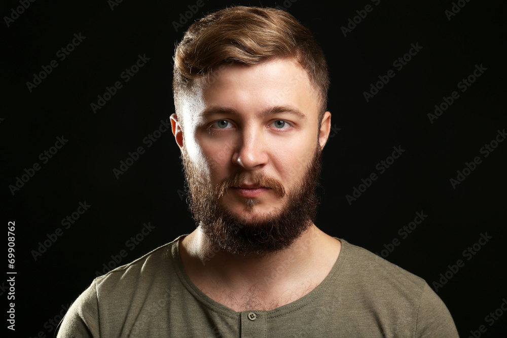 Portrait of handsome man with beard on black background