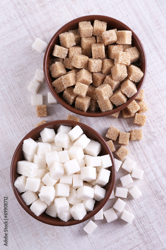 Brown and white refined sugar in color bowls