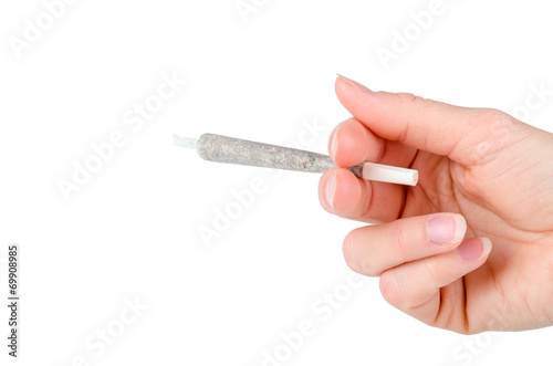 Womans hand holding marijuana joint isolated on white