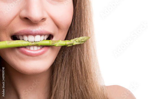Girl biting asparagus