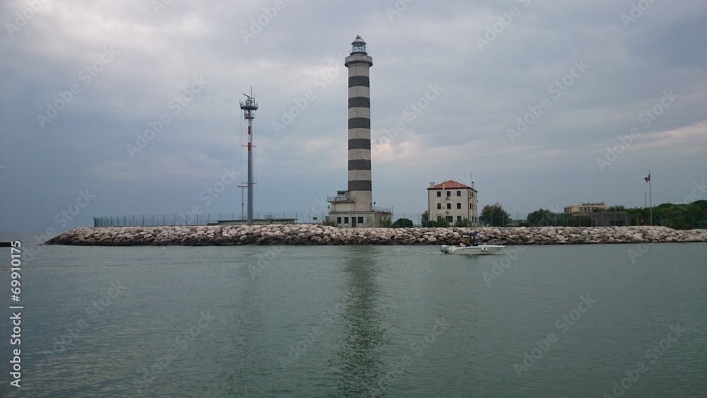Leuchtturm und Motorboot am Meer