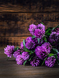Bouquet of blooming clover on the wooden background.