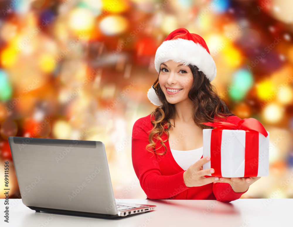 smiling woman in santa hat with gift and laptop smiling woman in santa hat with gift and laptop